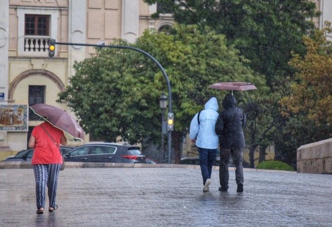 Diversos vianants passegen baix de la pluja a València