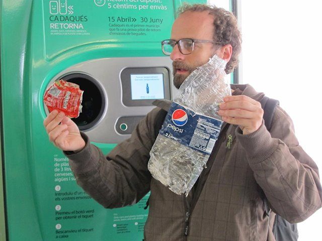 Un home amb dos envasos per a reciclar