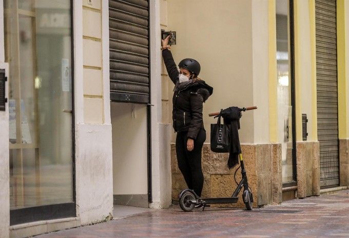 Una trabajadora cerrando un comercio