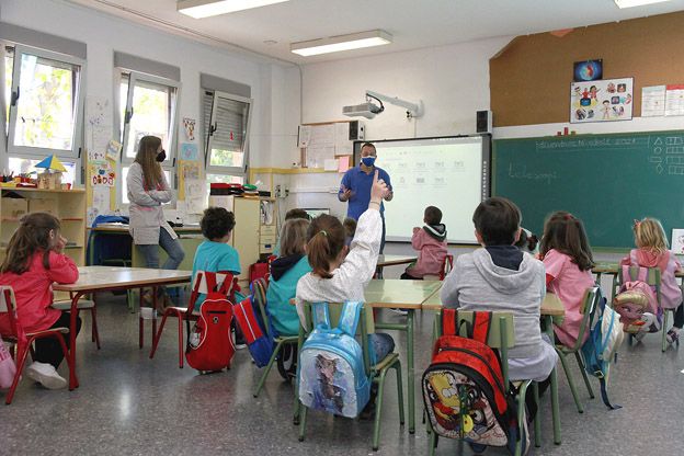 Unos niños y niñas de un colegio valenciano atienden a las explicaciones de un profesor