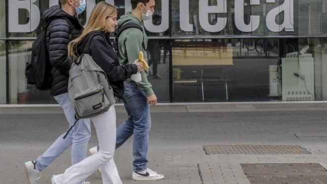 Un grup de tres estudiants a l'eixida de la biblioteca