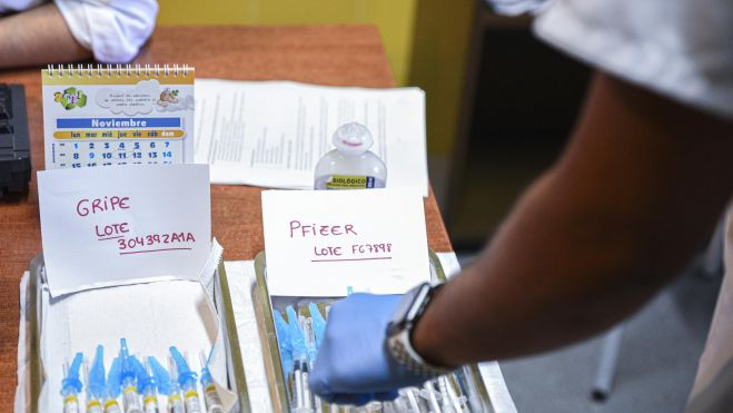 Dos bandejas con vacunas contra la gripe y con terceras dosis de la vacuna contra la COVID-19 Dos bandejas con vacunas contra la gripe y con terceras dosis de la vacuna contra la COVID-19