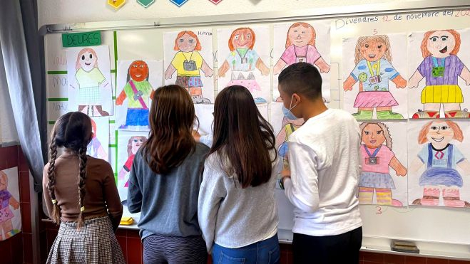 Xiquets mirant uns dibuixos en un centre educatiu de Benetússer