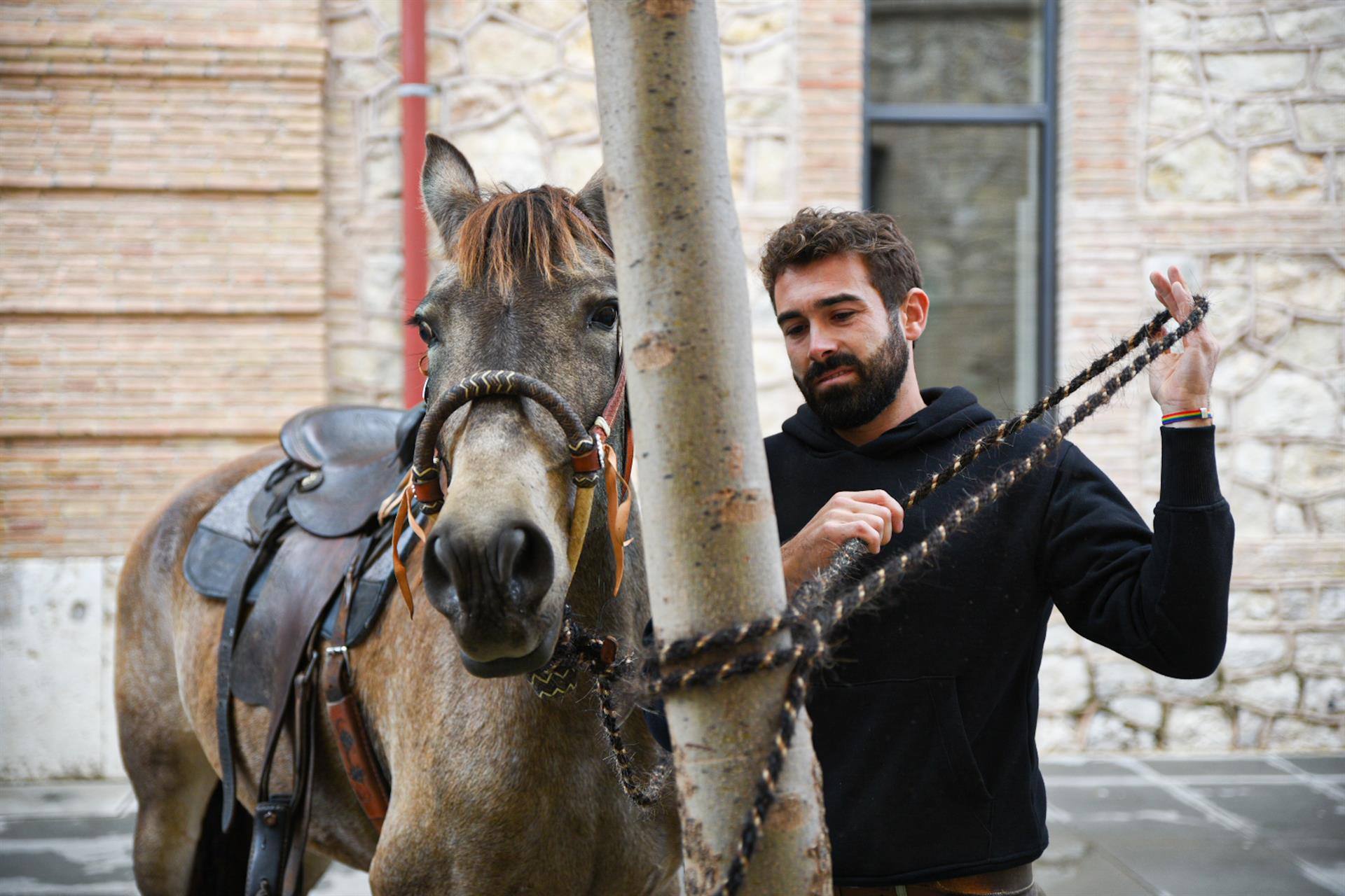 El joven ganadero Rubén Llata ata a su caballo, tras llegar a la Ciutat Administrativa Nou d'Octubre