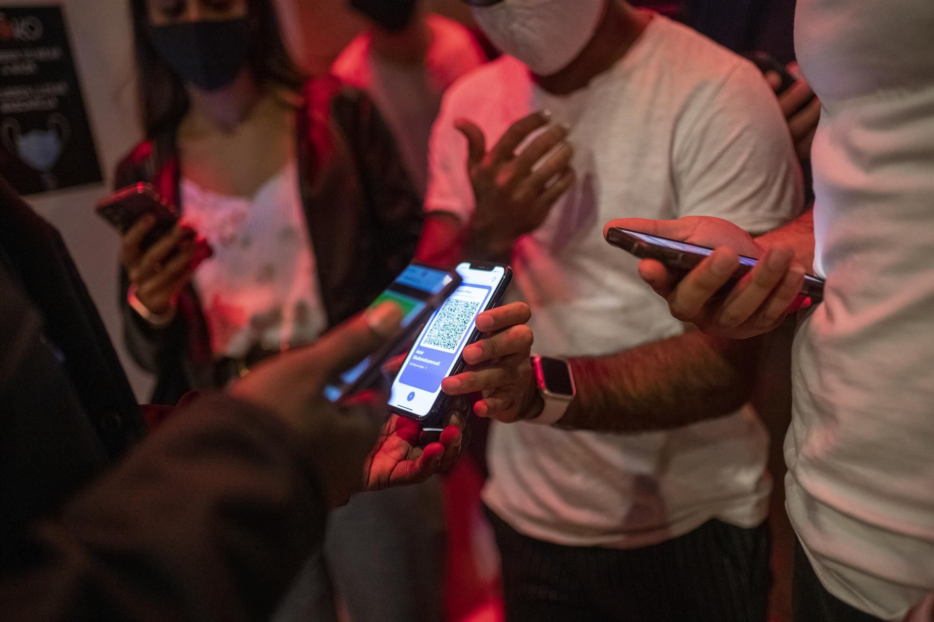 Una persona muestra un código QR para entrar a un local de ocio nocturno