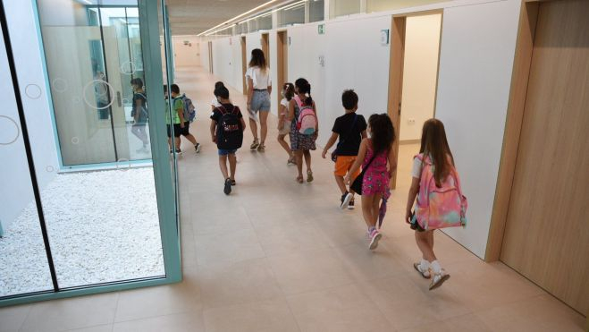 Una professora acompanya a alumnes d'Educació Primària en un col·legi de València