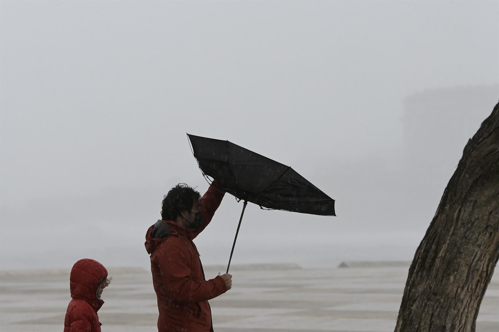 Dos personas caminando en un día de fuerte viento en Valencia