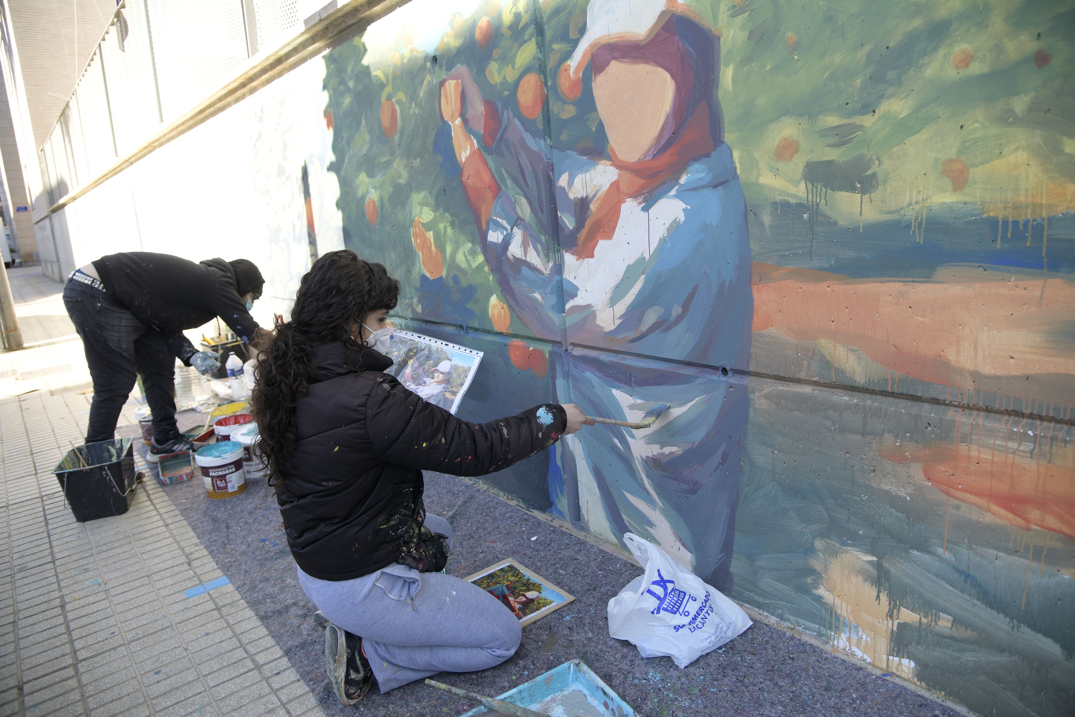 Artistas trabajando en uno de los murales que forman parte del certamen de arte urbano Encarna Jiménez