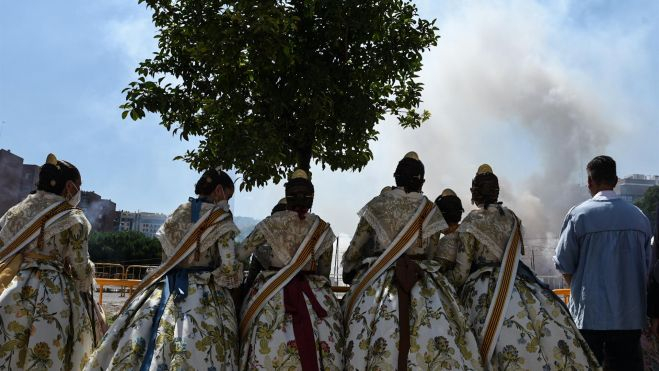 Un grupo de falleras observa la primera 'mascletà' de las Fallas de Valencia 2021