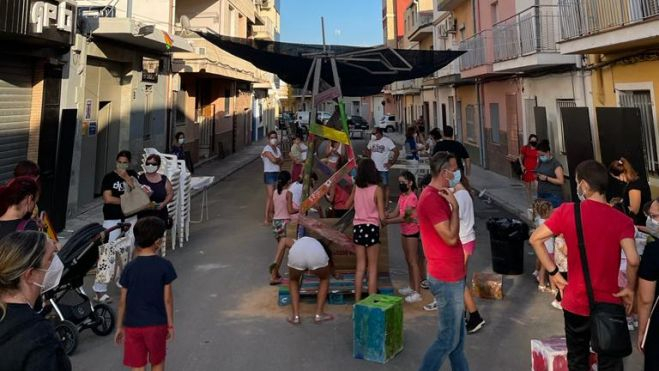 Un grup de fallers i falleres celebren els actes de Mig Any a la porta del casal