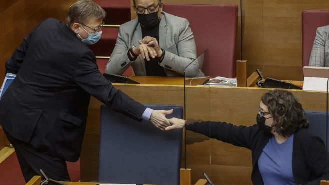El president de la Generalitat, Ximo Puig, y la vicepresidenta, Mónica Oltra, se dan la mano durante una sesión de control de Les Corts