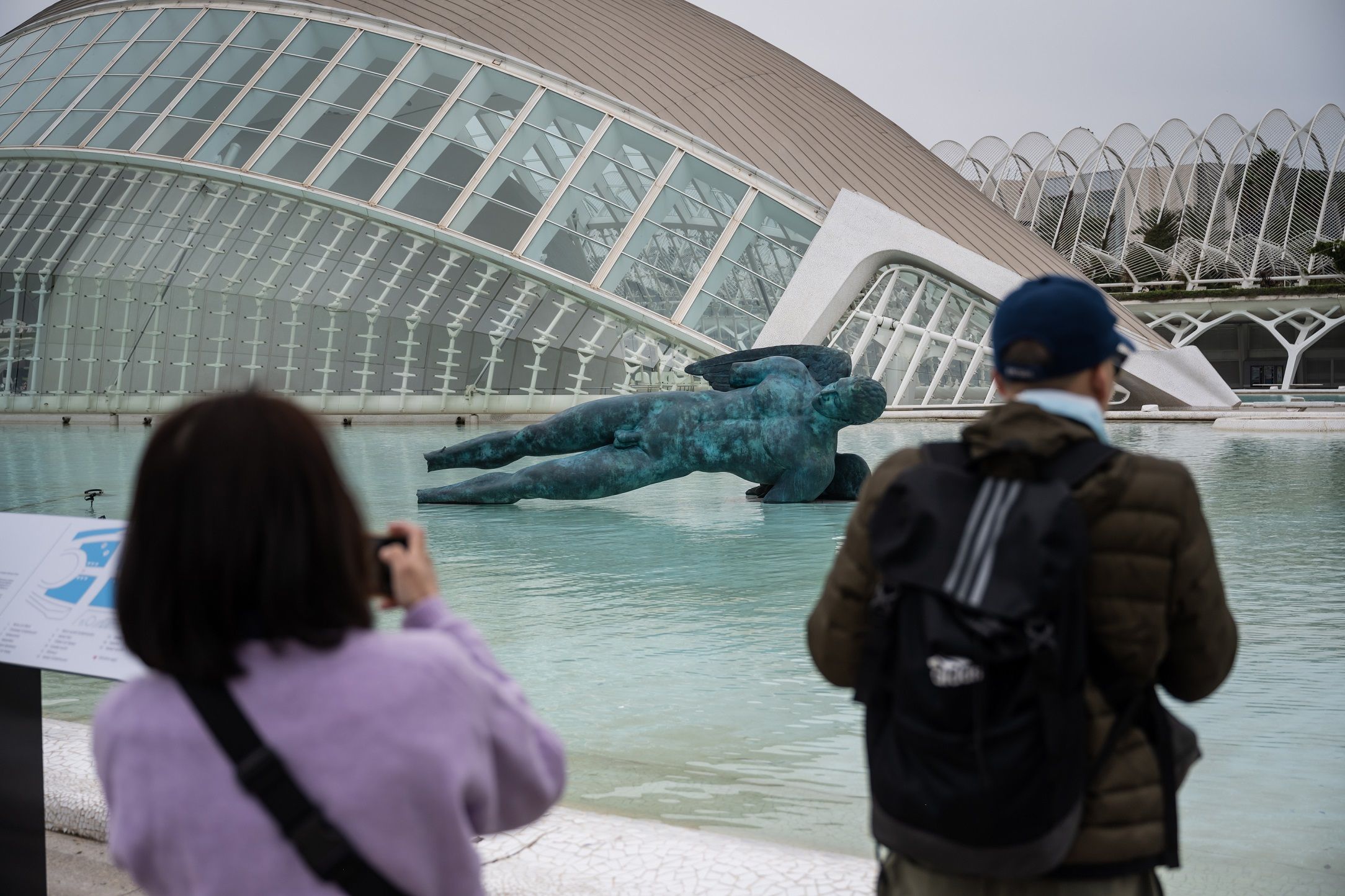 Dos visitantes fotografian una de las esculturas de Igor Mitoraj en la Ciutat de les Arts i les Ciències