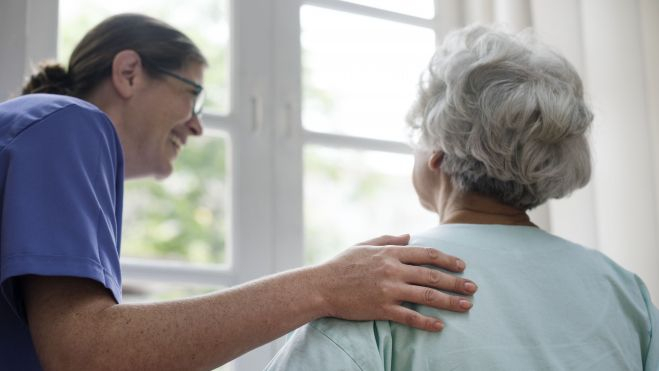 Enfermera cuidando a una anciana en una residencia