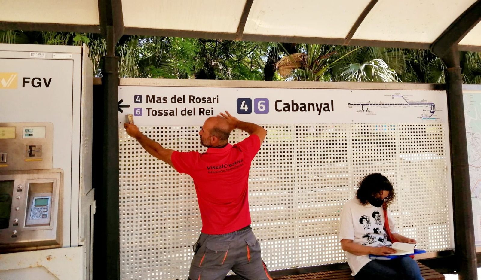 Un operario instala un nuevo soporte informativo en una parada de Metrovalencia
