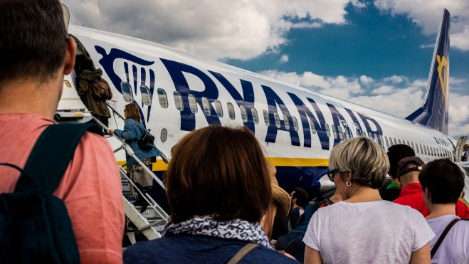 Varias personas esperan para subir a un avión de Ryanair