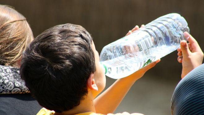 Un niño bebiendo agua debido al calor