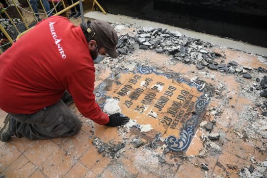 Trabajador de Arqueoantro limpiando la lápida de la fosa 114 de Paterna