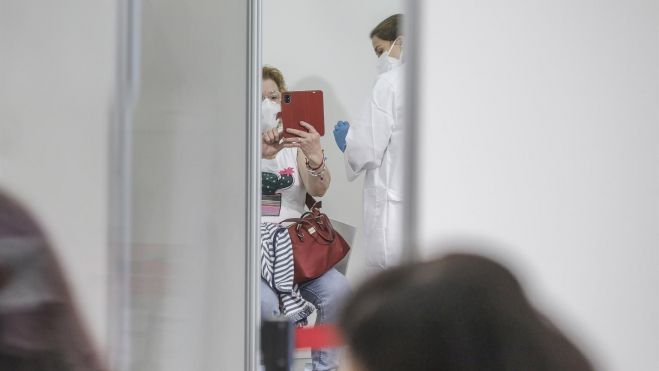 Una mujer se toma un selfie mientras es vacunada en el primer día de la vacunación masiva en la Comunidad Valenciana