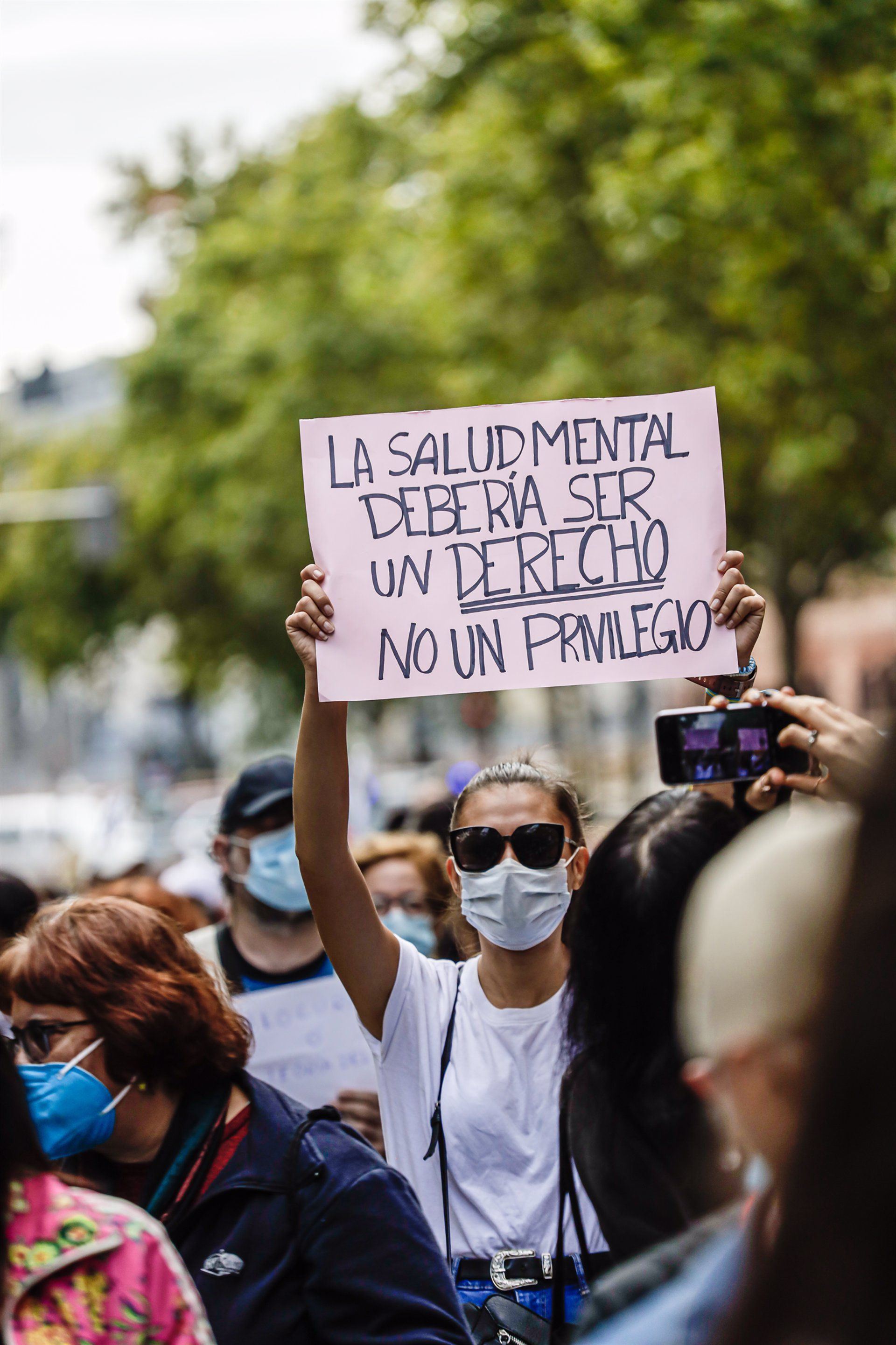 Una mujer sujeta una pancarta con un mensaje a favor de la salud mental durante una manifestación