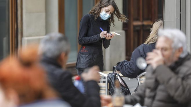 Una mujer trabajando de camarera en un bar Una mujer trabajando de camarera en un bar