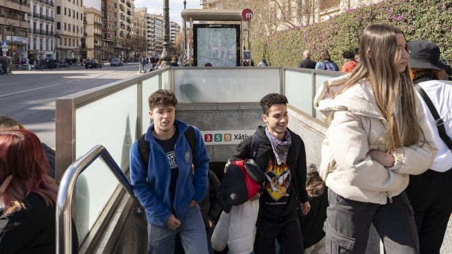 Dos joves ixen d'una parada de Metrovalencia en Falles. Imatge de Xisco Navarro