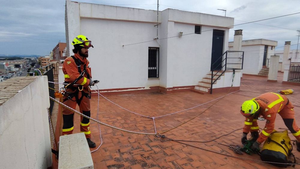 Dos bombers preparant el material abans de descendir per la façana d'un edifici