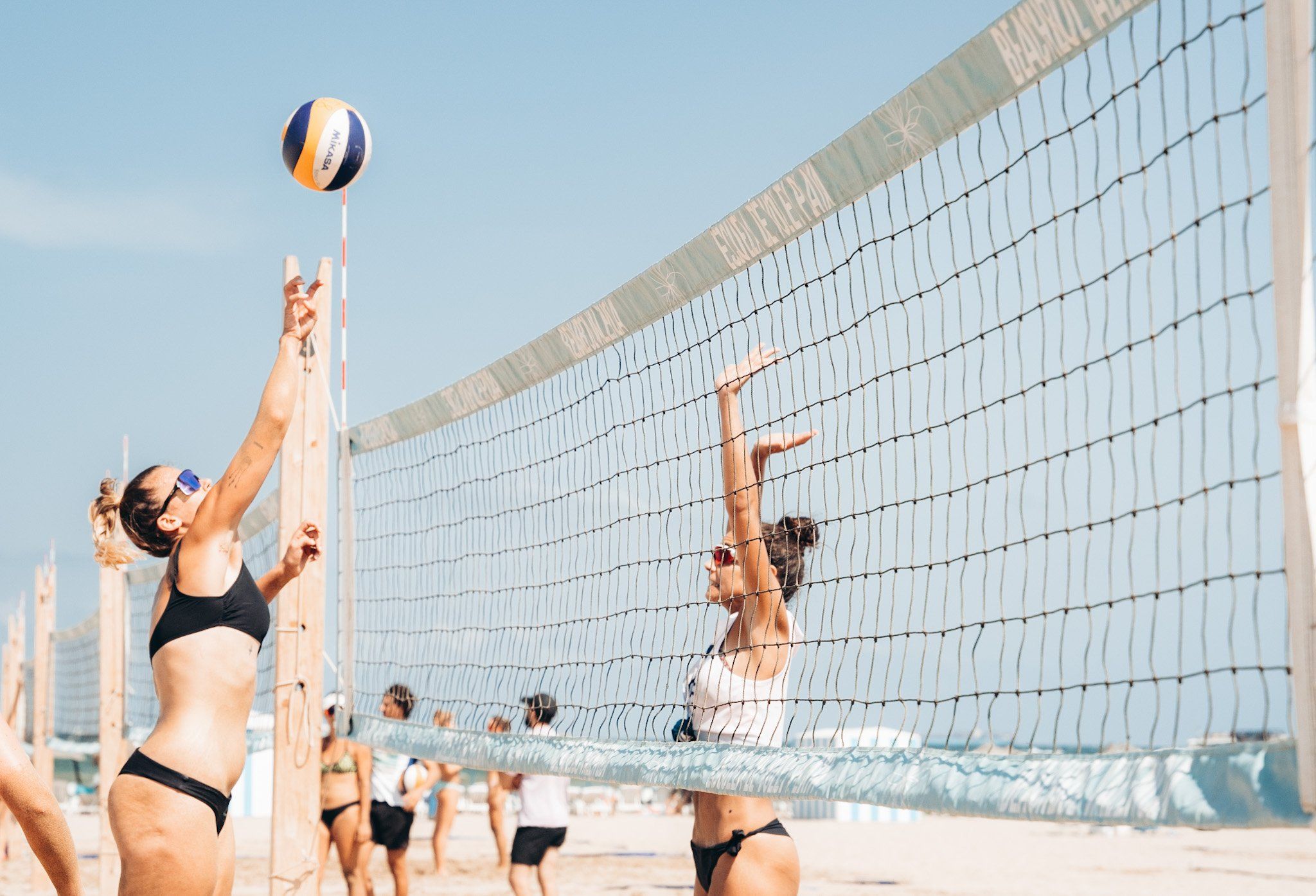 Un grupo de personas juegan al voleibol en la playa