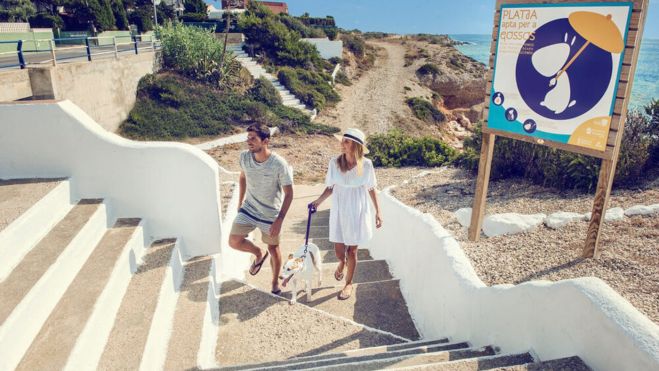 Una parella i el seu gos gaudeix de la cala de les Llanetes, platja canina de Vinaròs