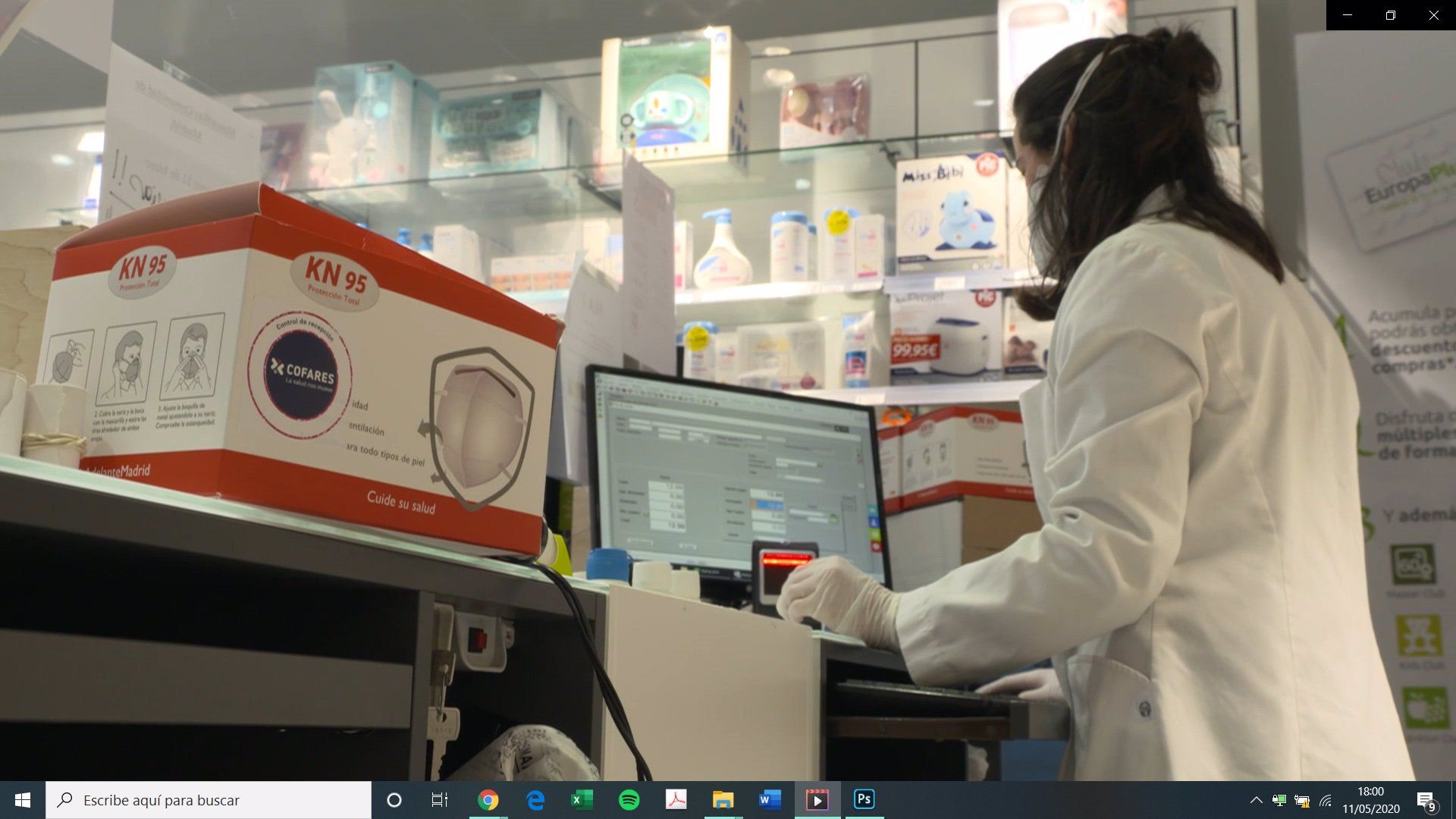 Una trabajadora de una farmacia con una mascarilla