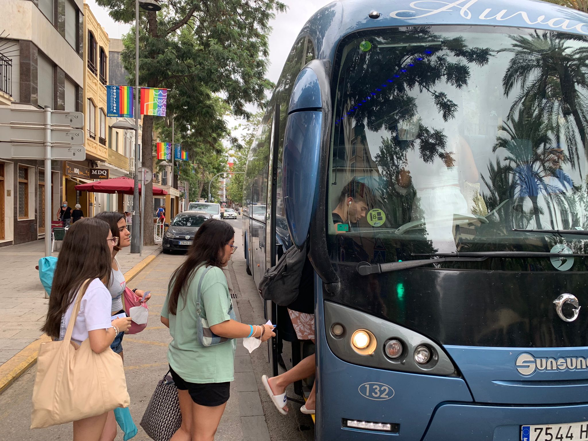 Un grup de joves pugen a l'autobús a Catarroja per a anar a la platja gràcies a la iniciativa Cata-rosa