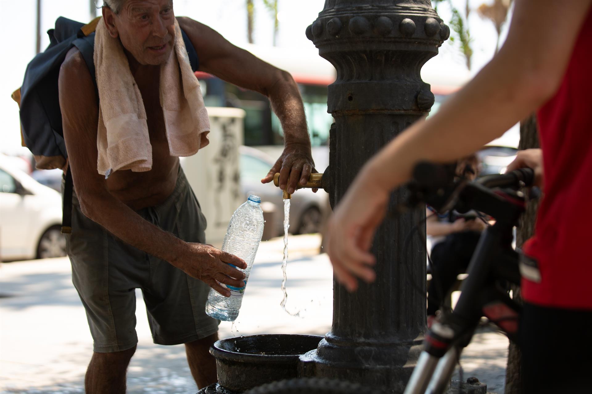 Un home plena d'aigua una botella per a refrescar-se contra les altes temperatures