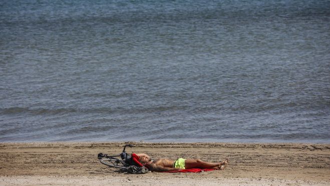 Un home tombat al costat del mar. Imatge: Rober Solsona - Europa Press