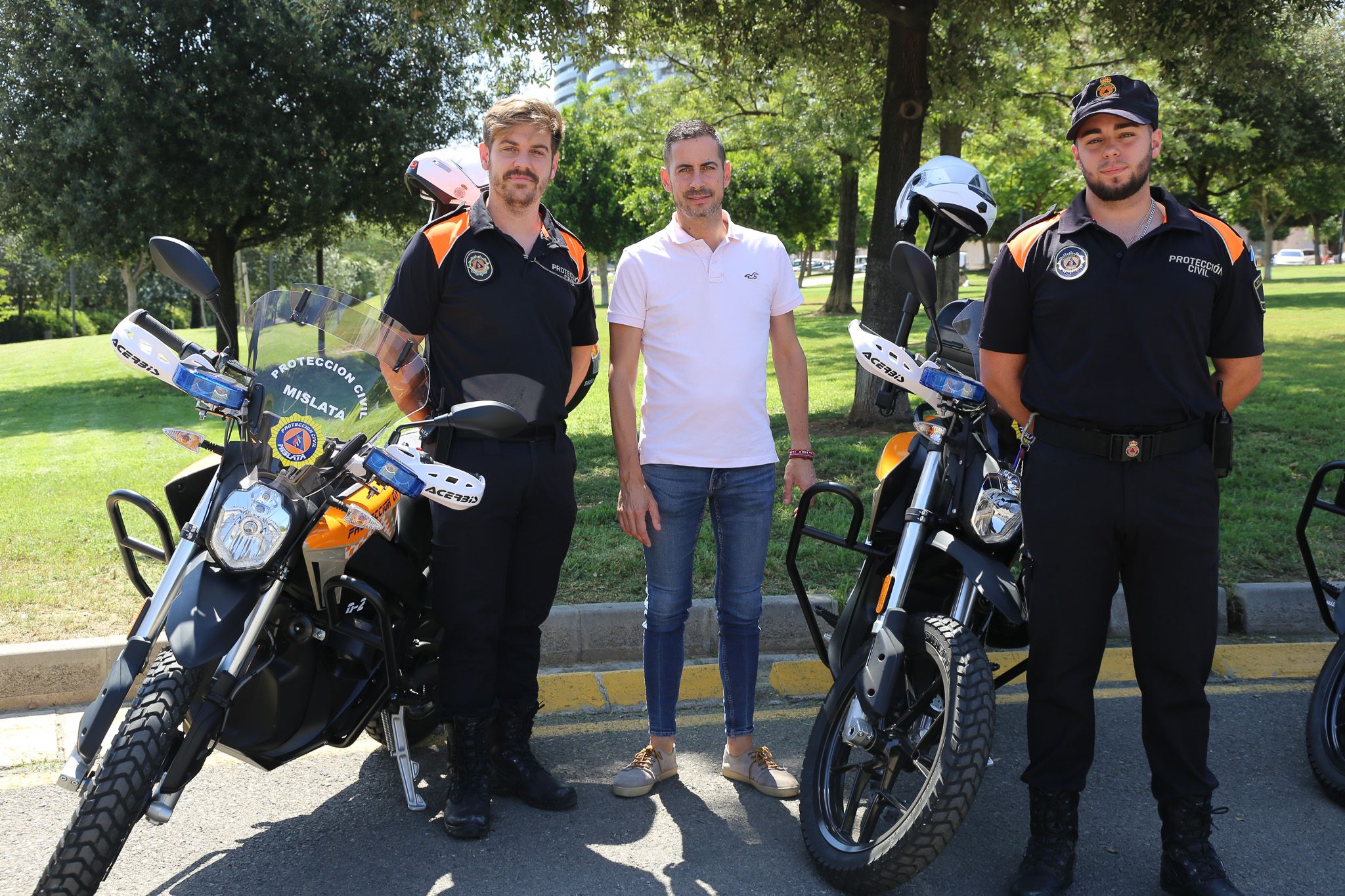 L'alcalde de Mislata, Carlos F. Bielsa, junt amb dos operaris de Protecció Civil en la presentació dels vehicles elèctrices
