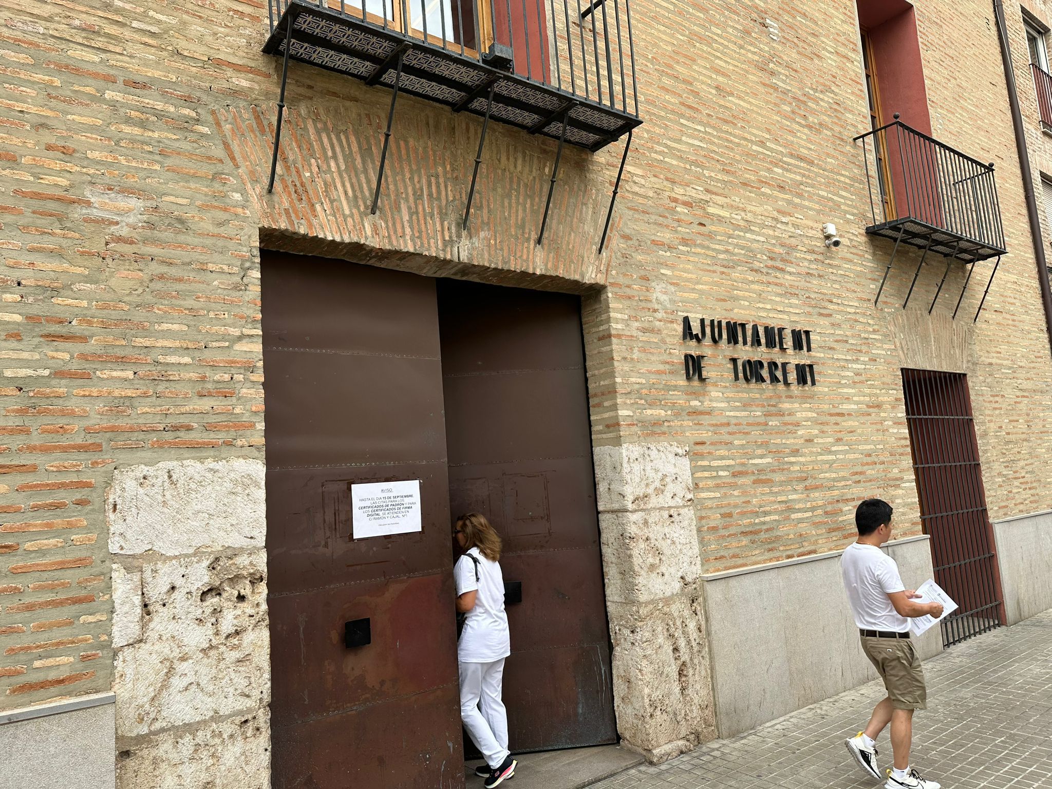 Dues persones en els voltants d'una edifici de l'Ajuntament de Torrent