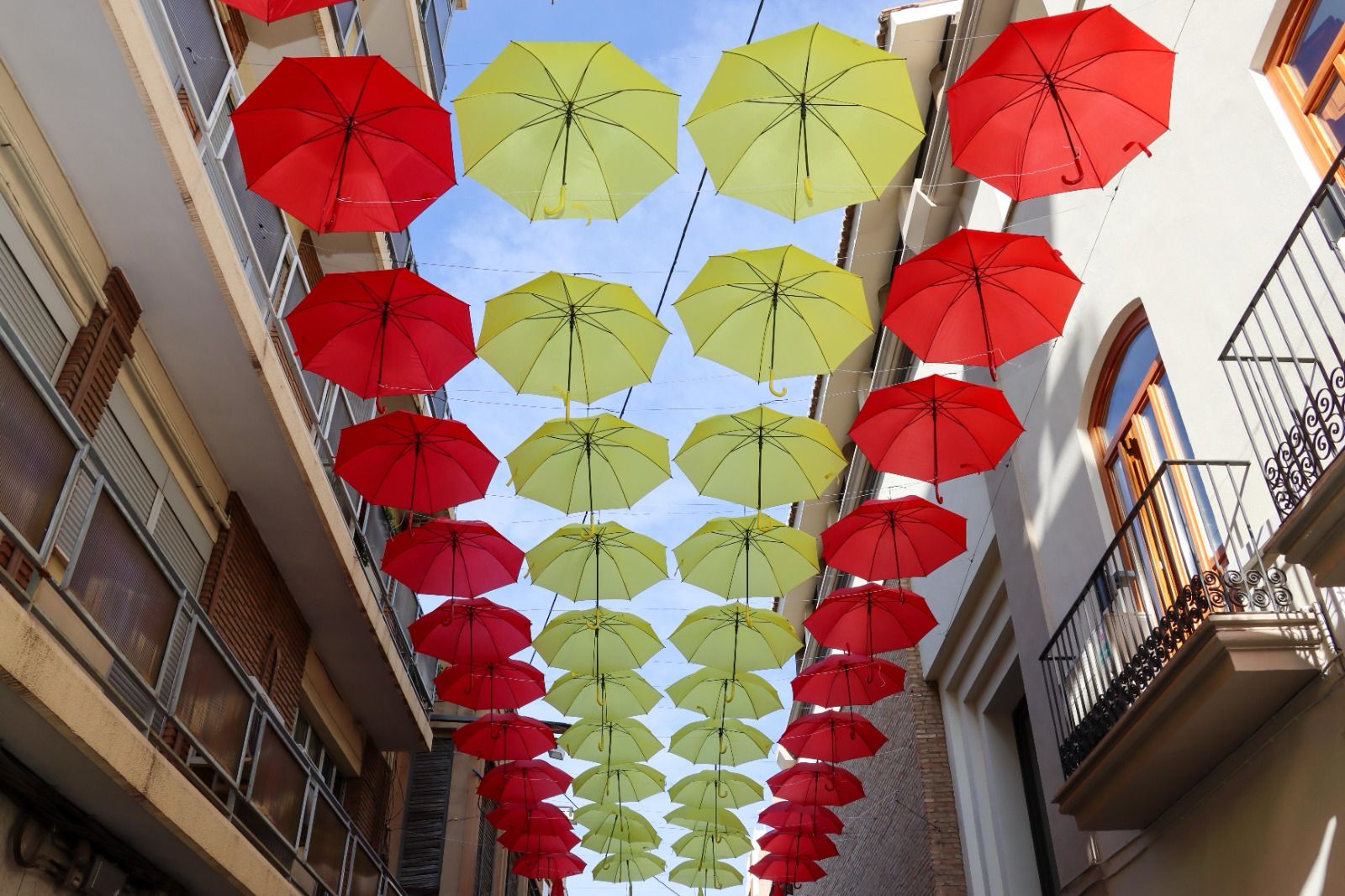Paraguas de color rojo y amarillo forman la bandera de España en la calle Sagra de Torrent