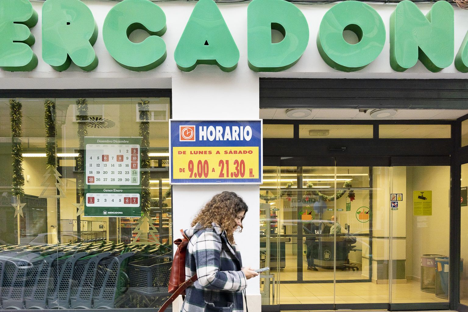 Una mujer pasa por delante de un supermercado de València. Foto de Xisco Navarro