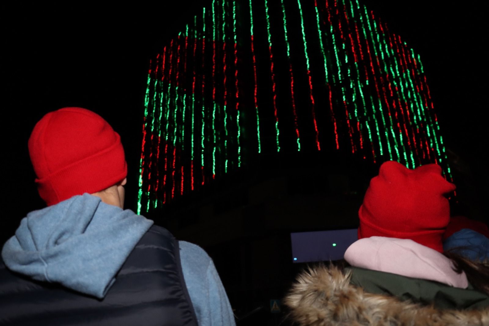 Dos personas disfrutando del espectáculo de luces en el Ayuntamiento de Torrent