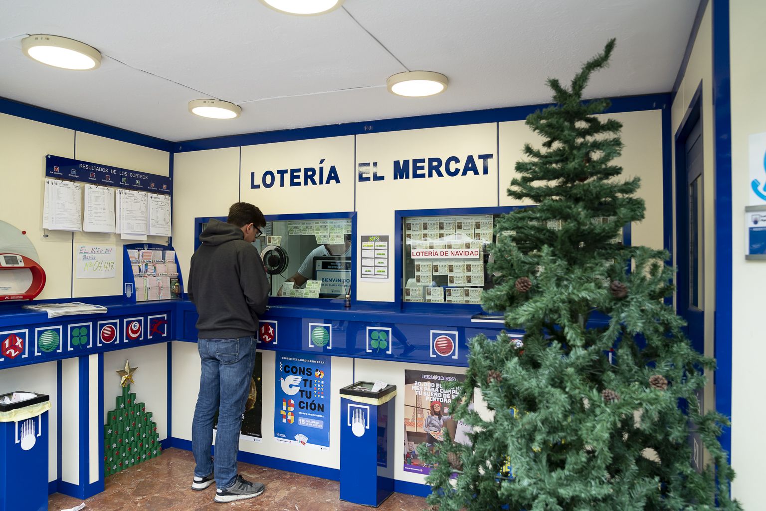 Una persona comprando lotería en la administración El Mercat en Valencia - Xisco Navarro