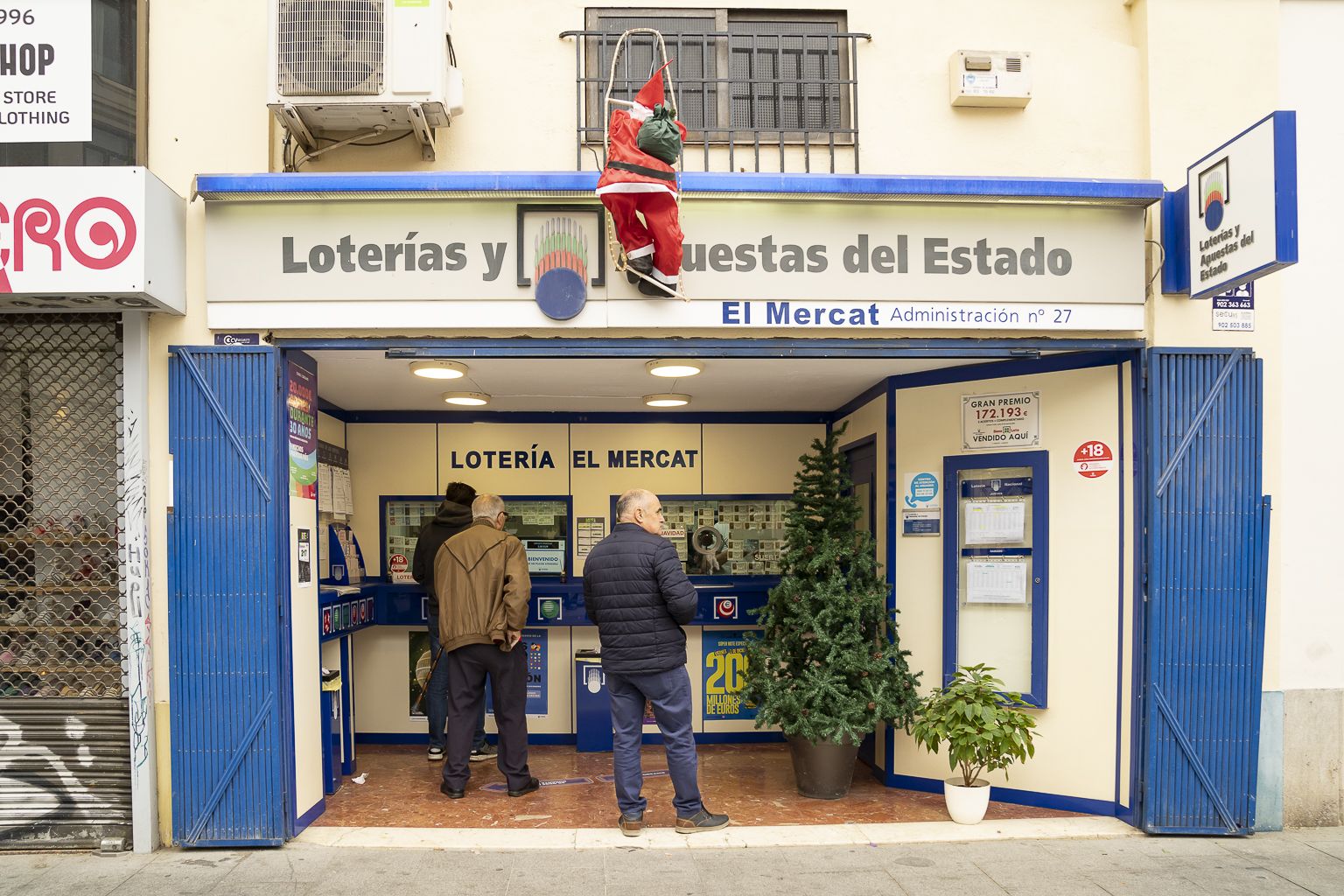 Gente comprando lotería de Navidad en una administración de València. Foto Xisco Navarro