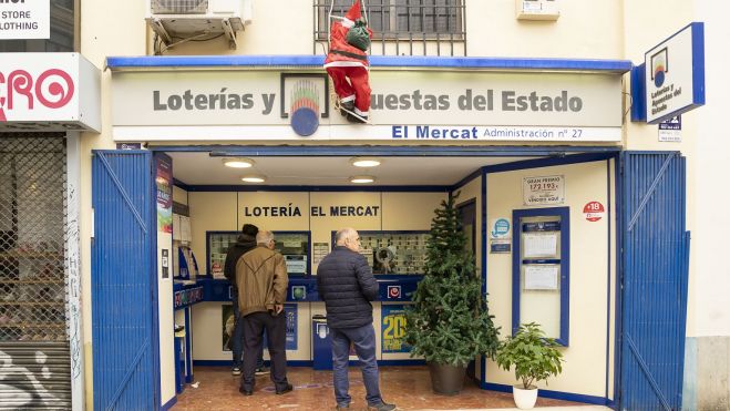 Gente comprando lotería de Navidad en una administración de València. Foto Xisco Navarro