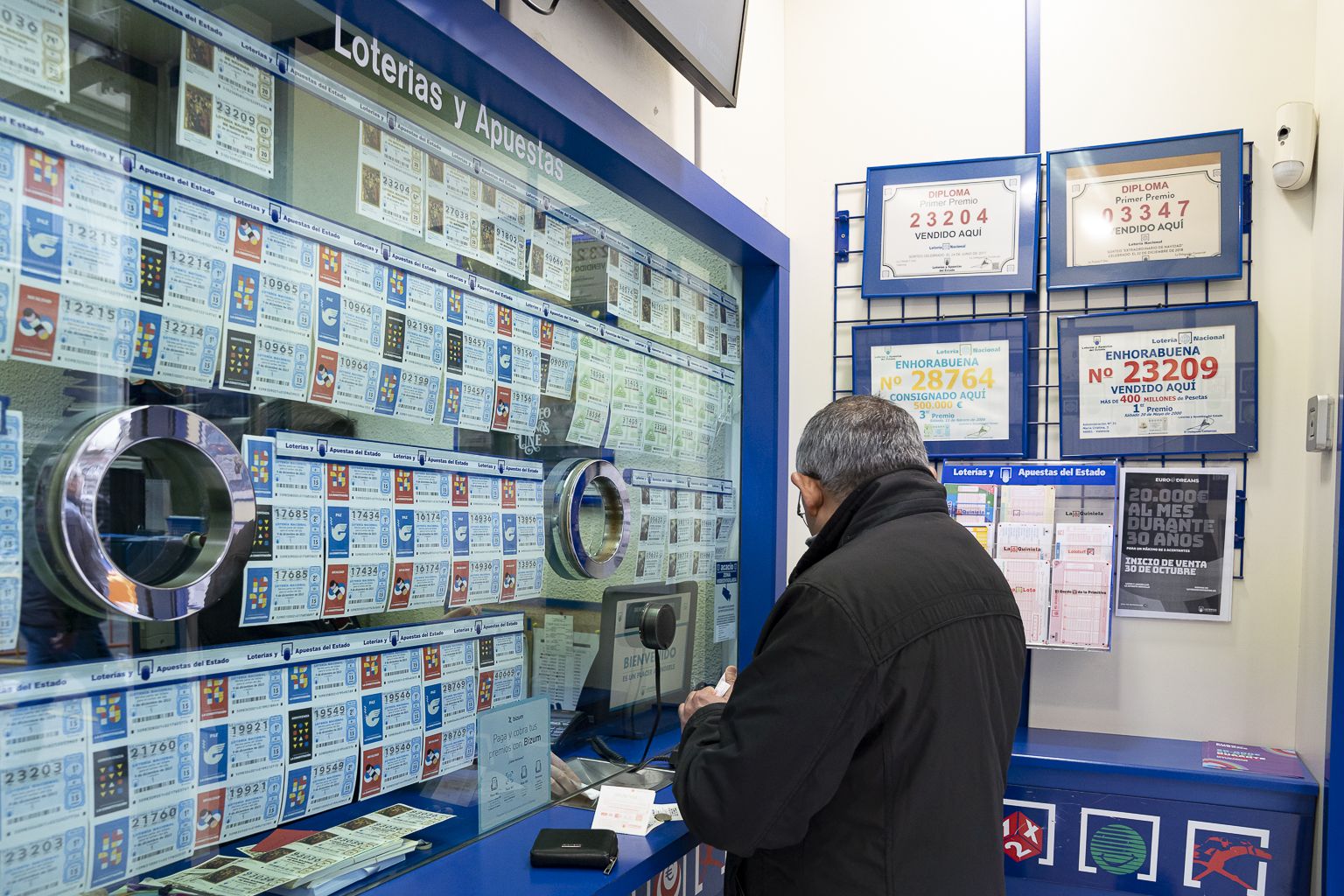 Gent comprant loteria de Nadal en una administració de València. Foto Xisco Navarro