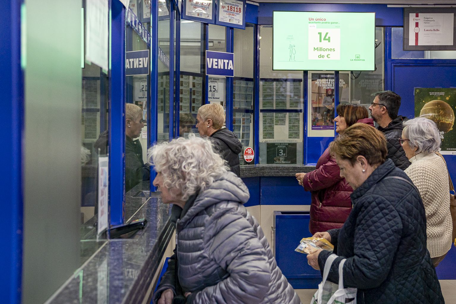 Gent comprant loteria de Nadal en una administració de València. Foto Xisco Navarro