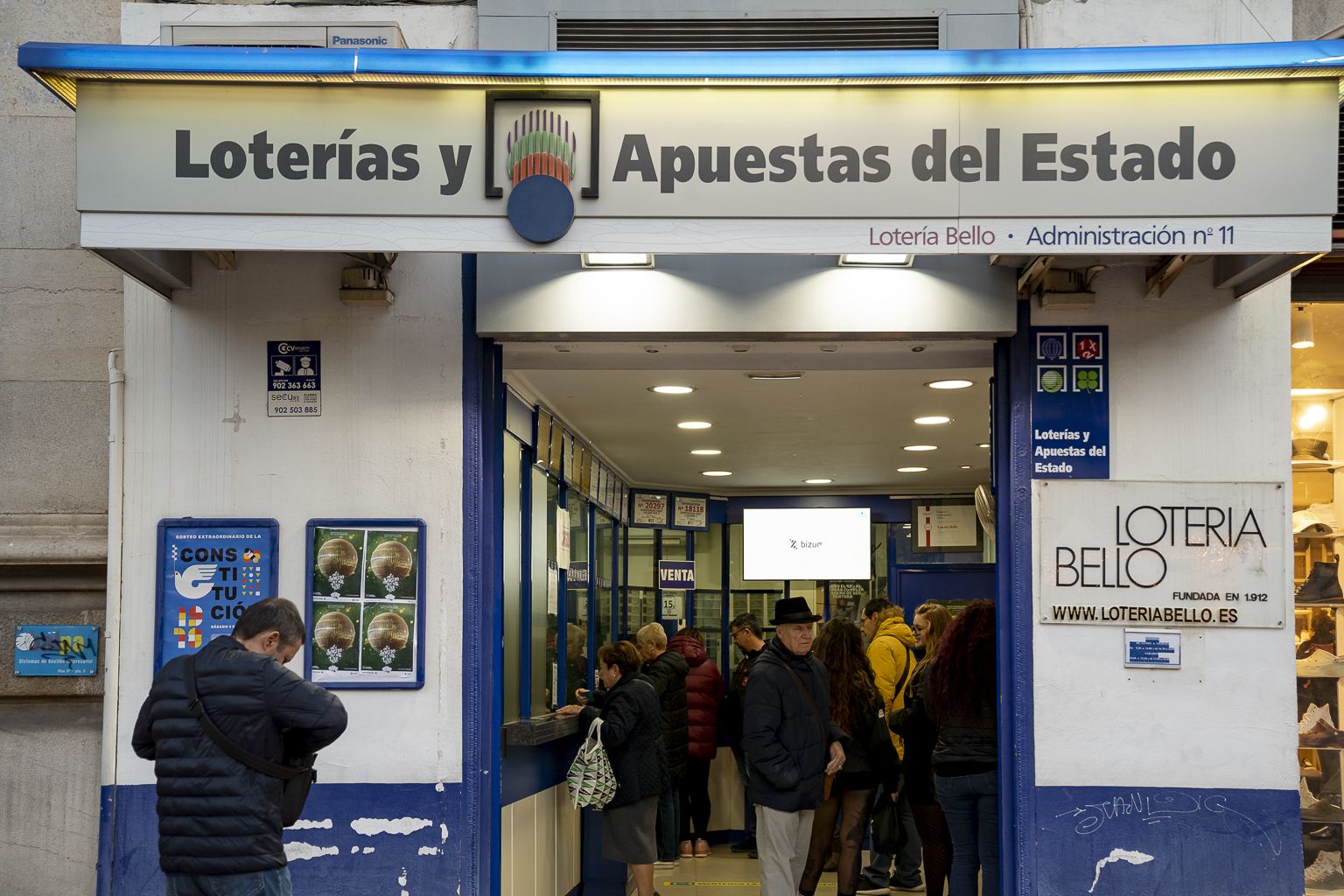 Gente comprando lotería de Navidad en una administración de València. Foto Xisco Navarro