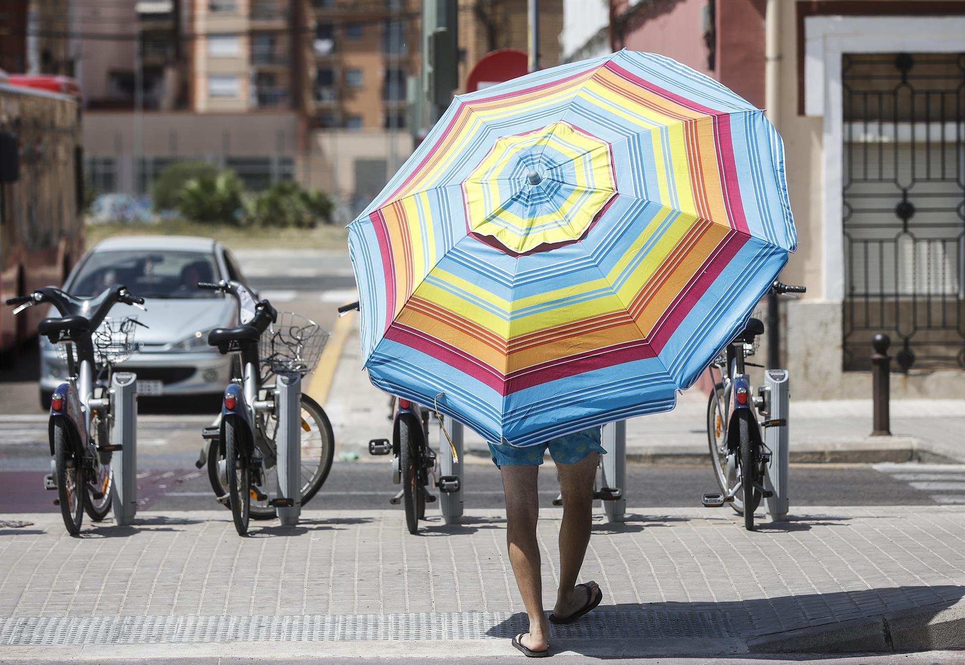 Un hombre con una sombrilla cerca de la Playa de la Malvarrosa (Valencia), - Rober Solsona - Europa Press