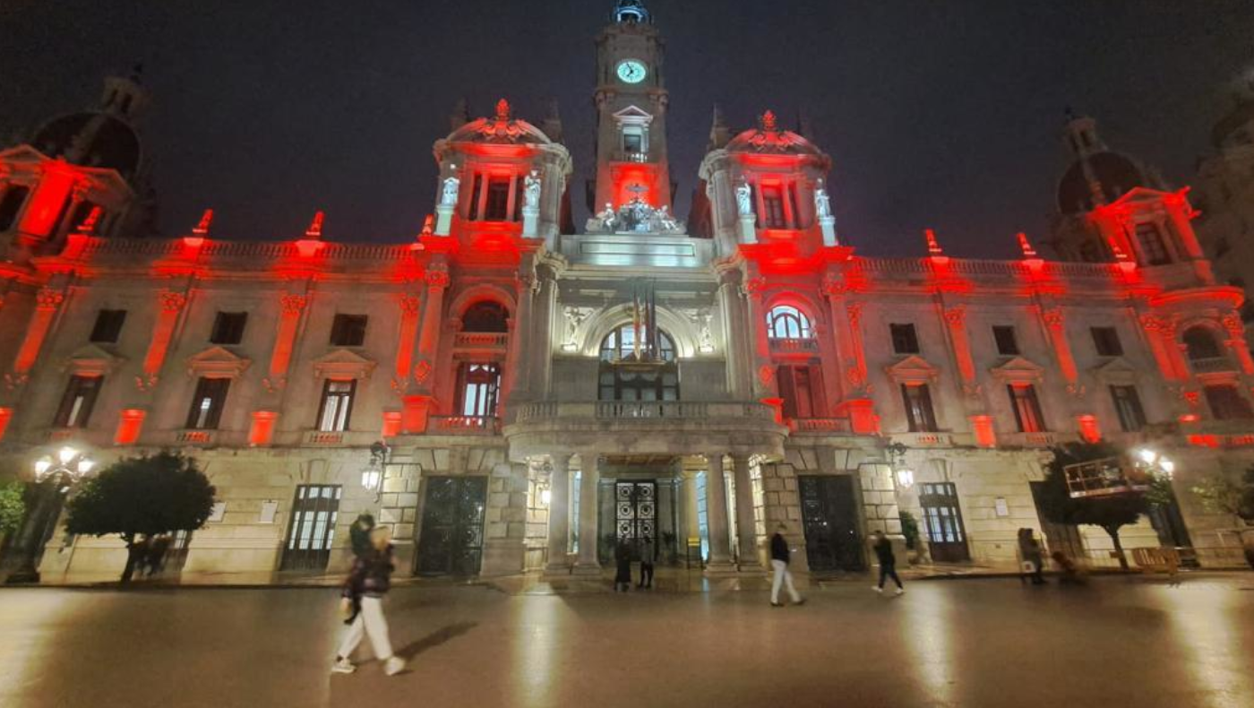 Fachada del Ayuntamiento de València teñida de rojo