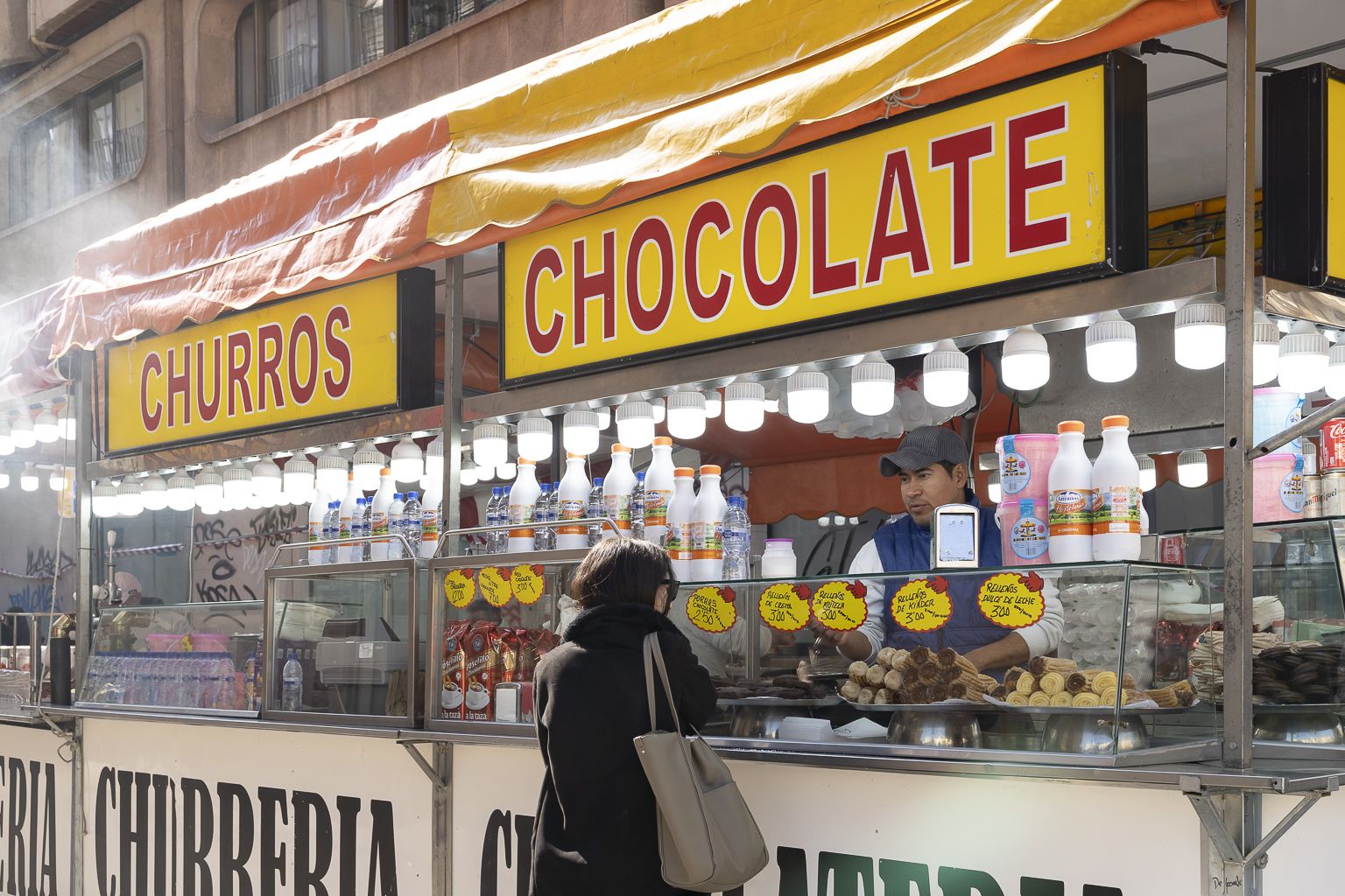 Puesto de churros y buñuelos durante las Fallas de Valencia  / Foto: Xisco Navarro