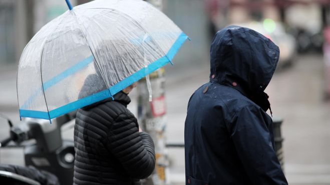 Dos personas con paraguas bajo la lluvia