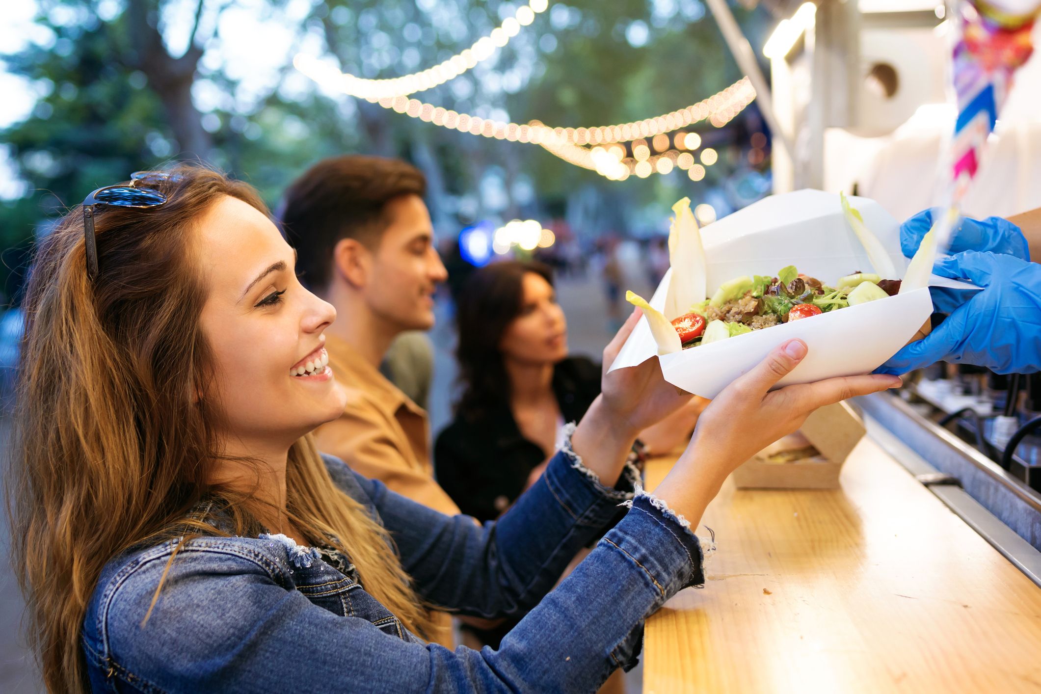 Una chica disfruta de una comida en una food truck