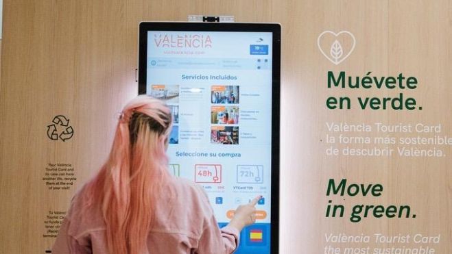 Una usuaria consulta información turística de València en una máquina Una usuaria consulta información turística de València en una máquina