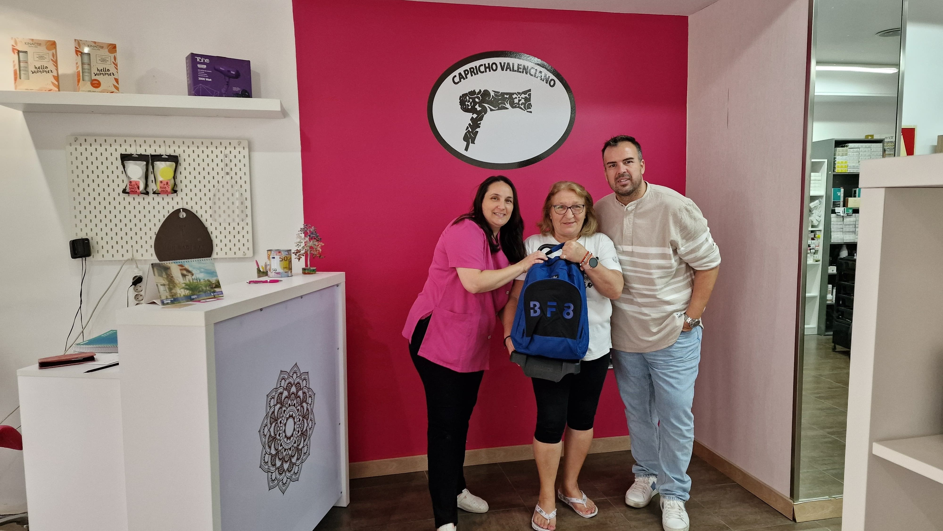 El concejal de Comercio durante la entrega de un pack de material escolar a la ganadora en un establecimiento de Paterna.